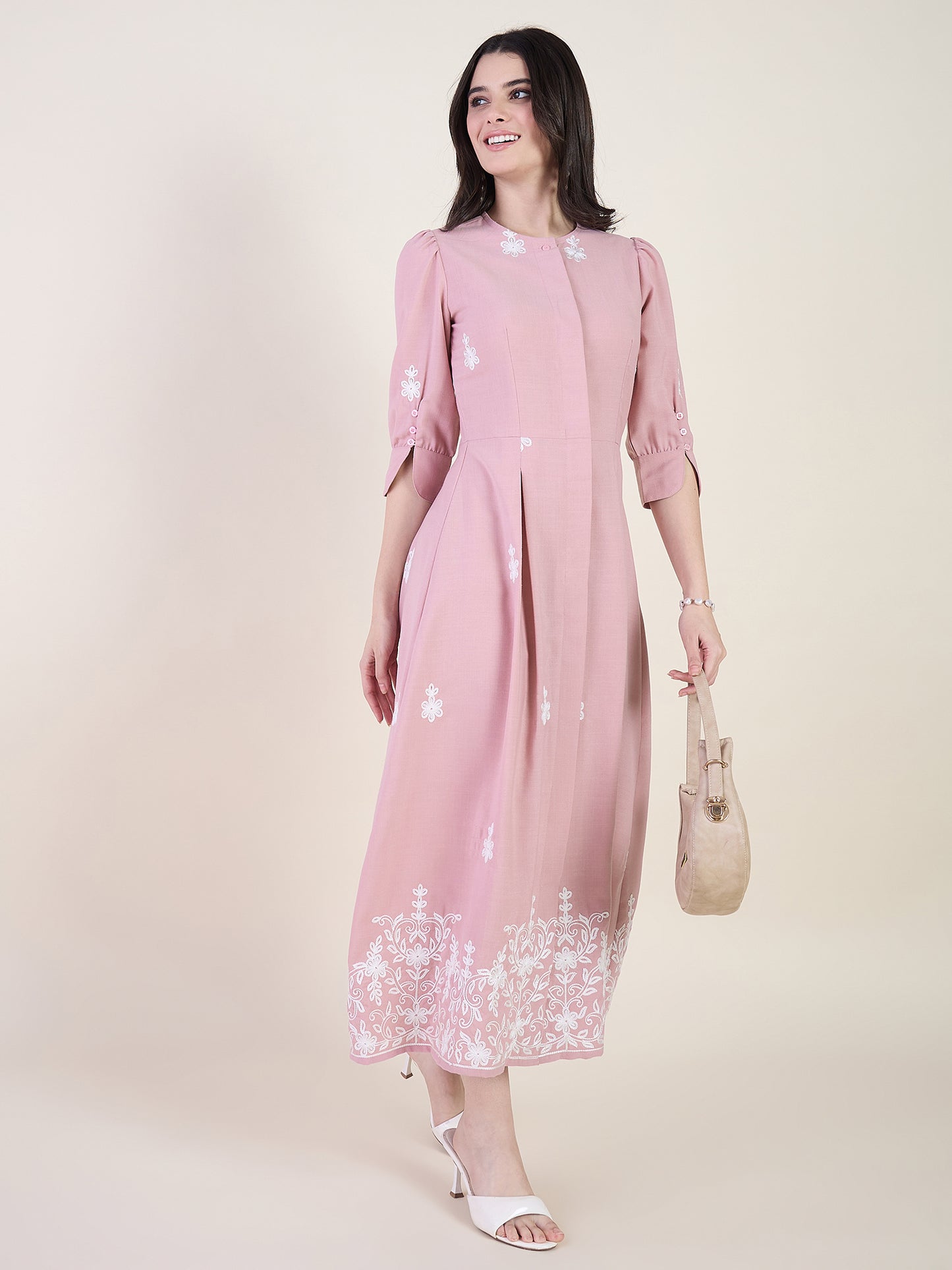 Blush pink embroidered midi dress on beige background