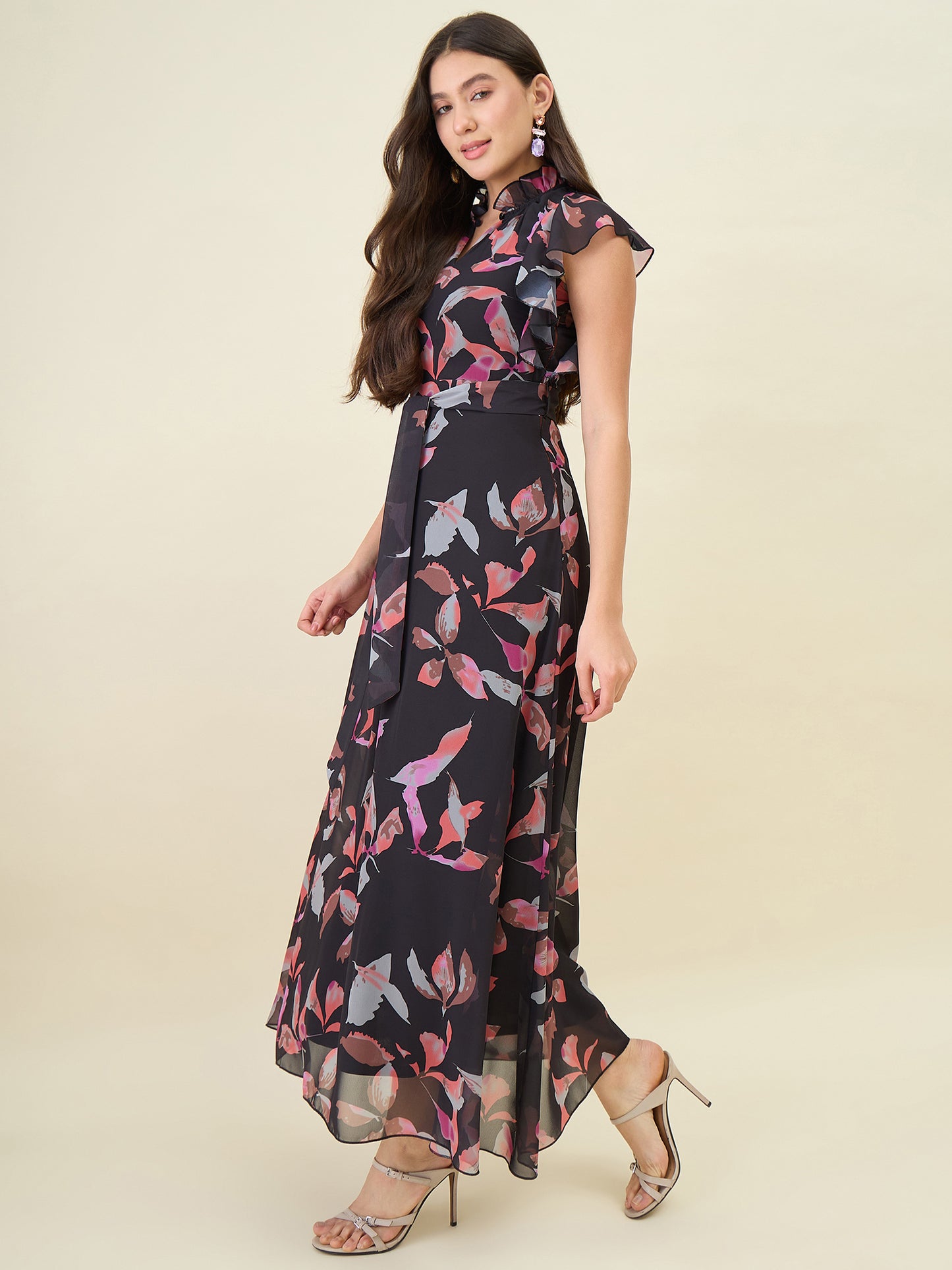 Woman wearing a black floral dress on a beige background