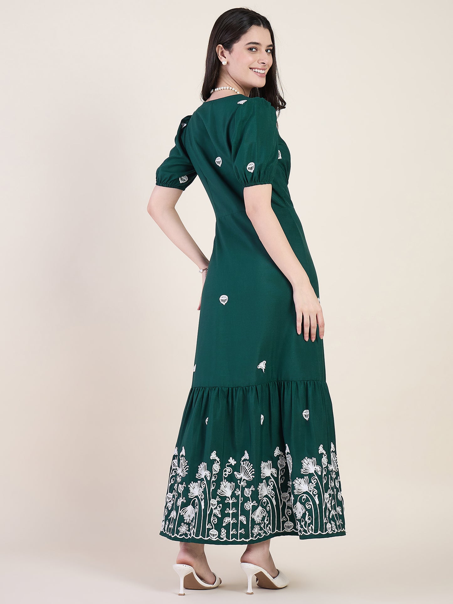 Emerald green embroidered maxi dress on beige background