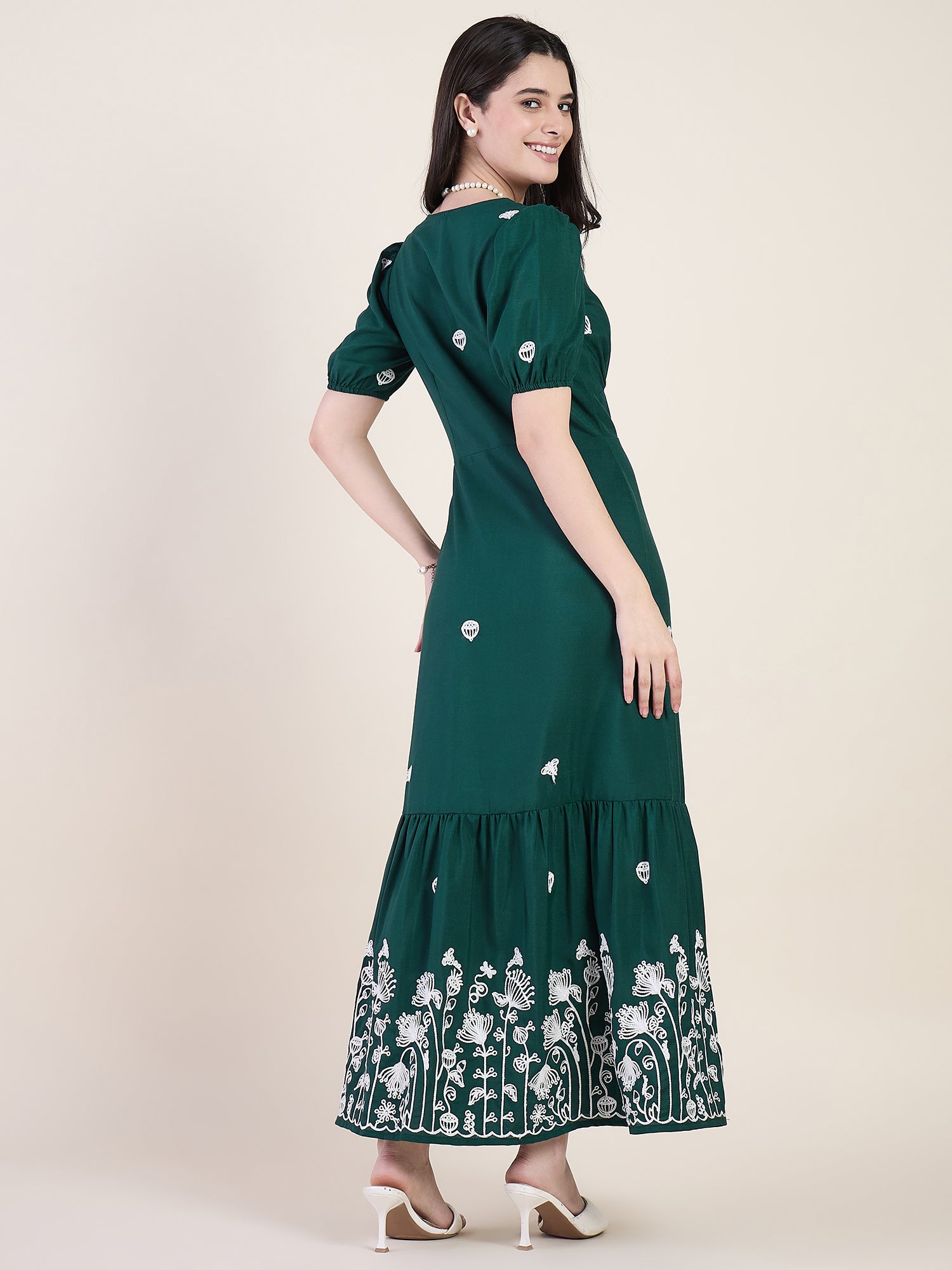 Emerald green embroidered maxi dress on beige background