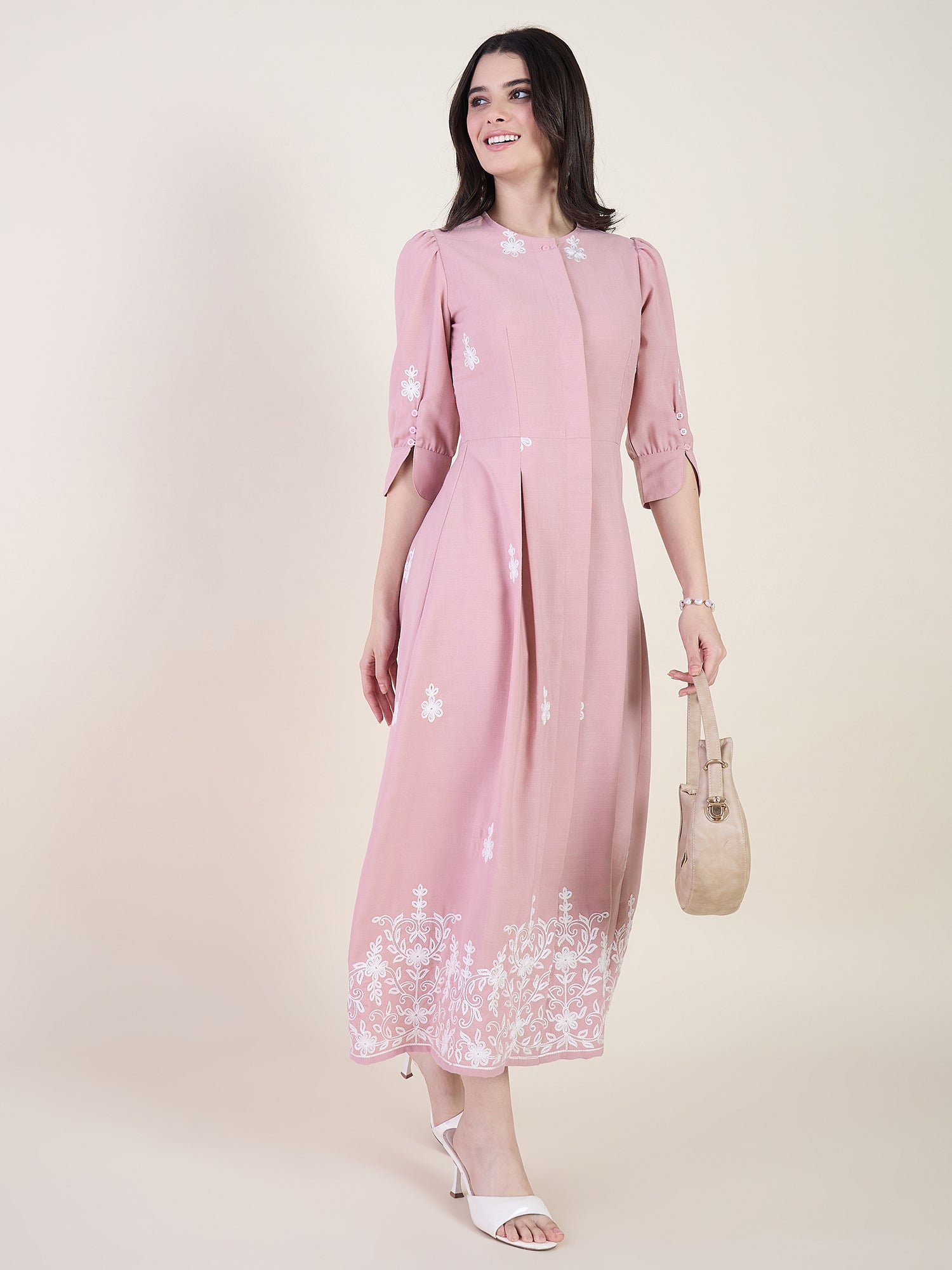 Blush pink embroidered midi dress on beige background