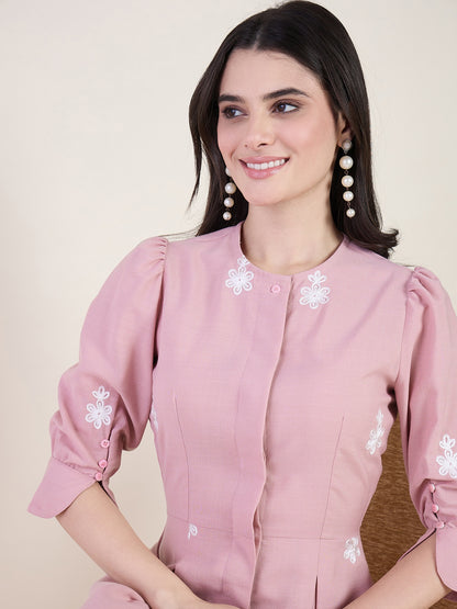 Blush pink embroidered midi dress on beige background