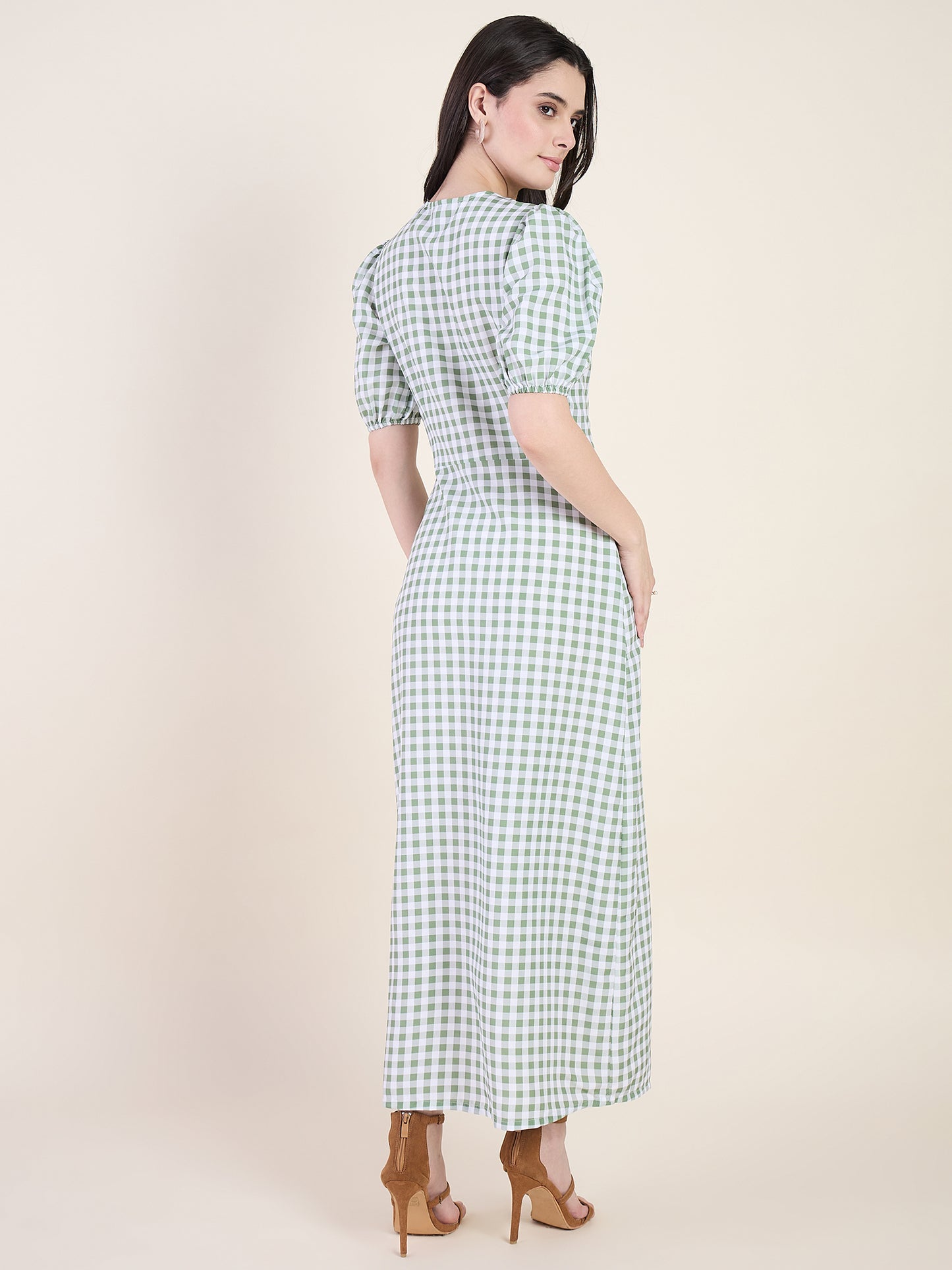 Woman wearing a green checkered dress on a beige background