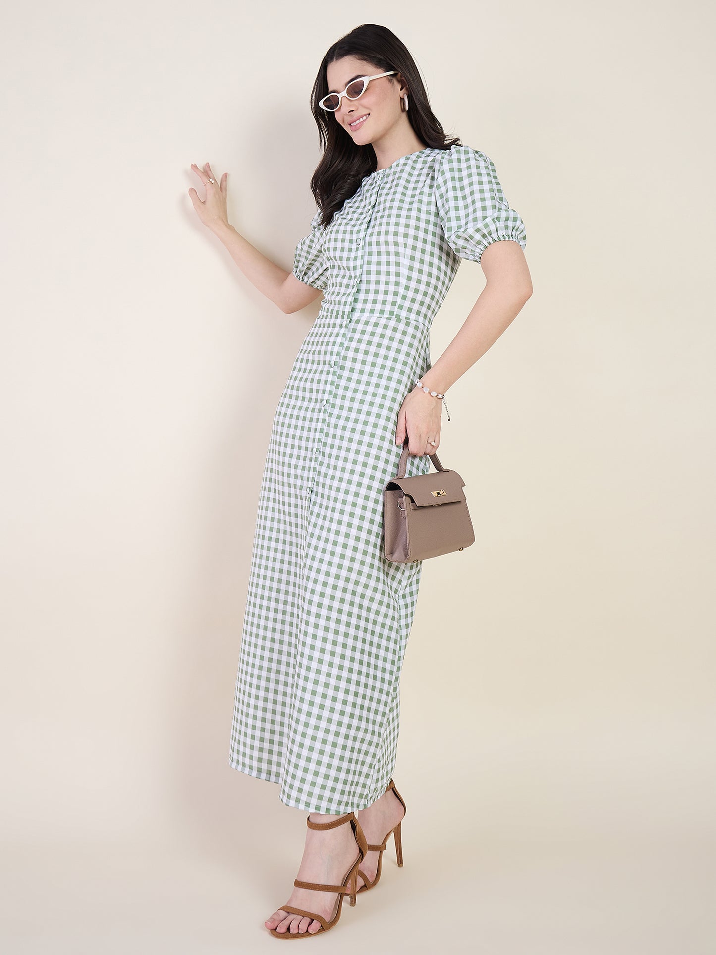 Woman wearing a green checkered dress on a beige background