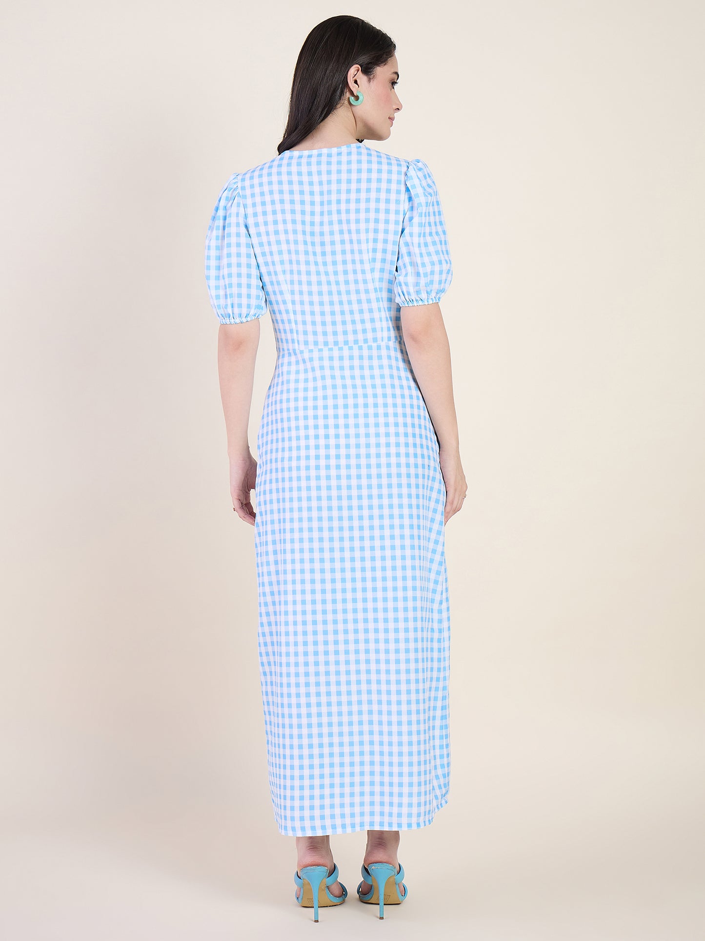 Woman wearing a blue checkered dress on a beige background