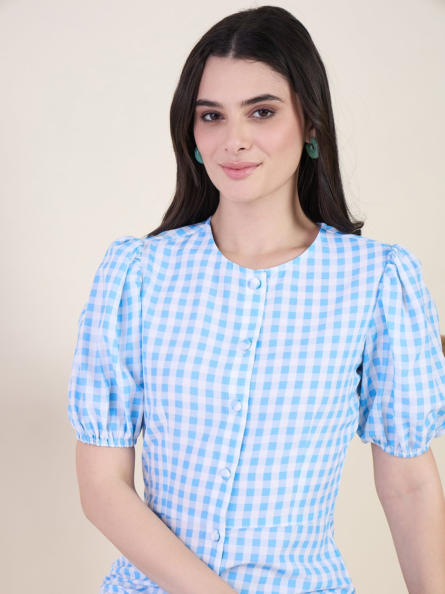 Woman wearing a blue checkered dress on a beige background