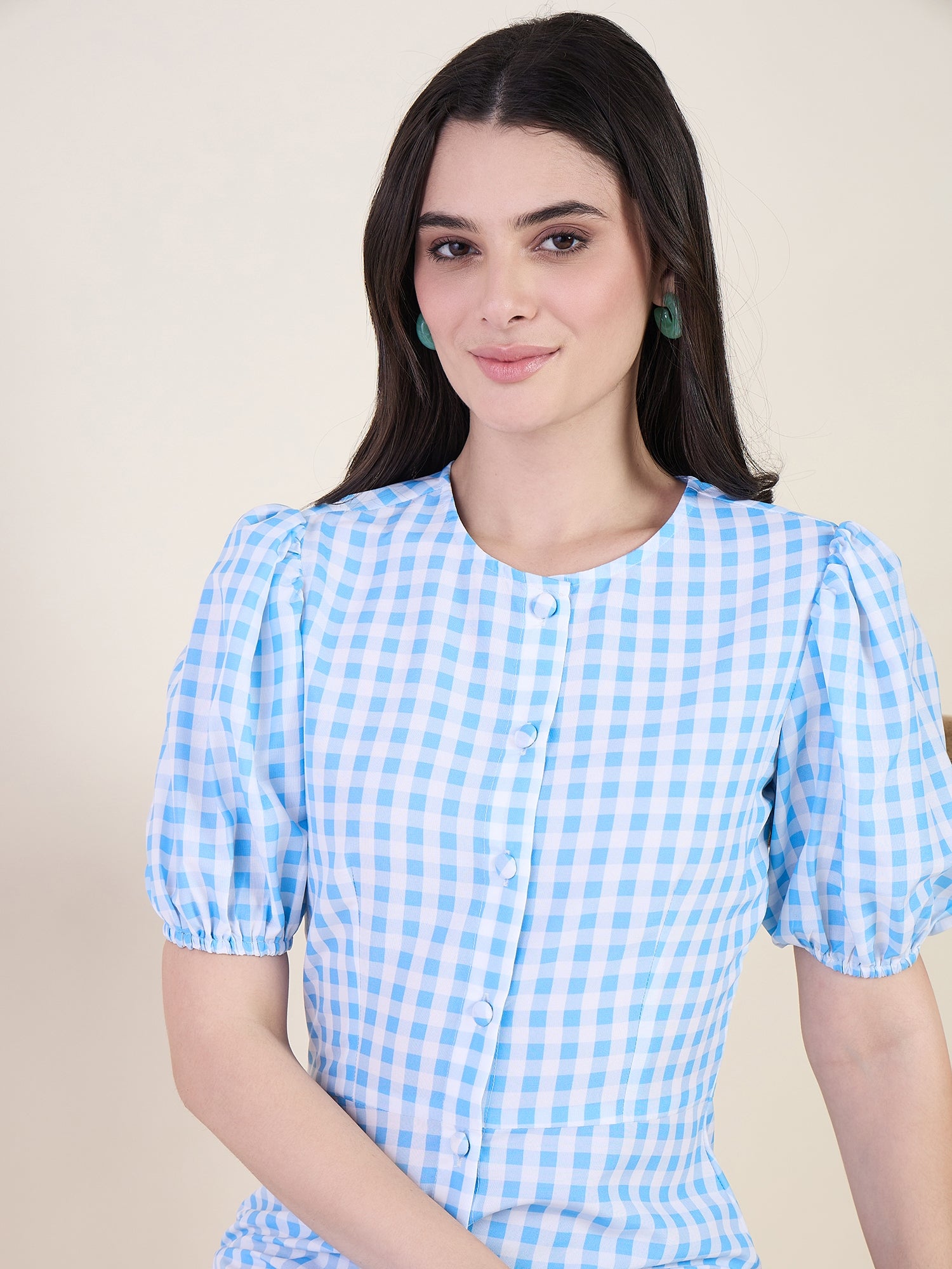 Woman wearing a blue checkered dress on a beige background