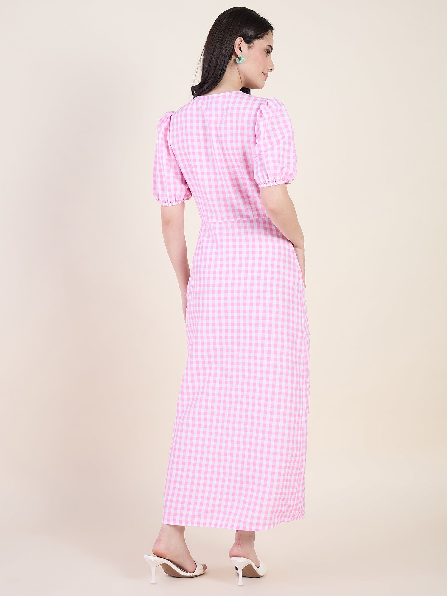 Woman wearing a pink checkered dress on a beige background