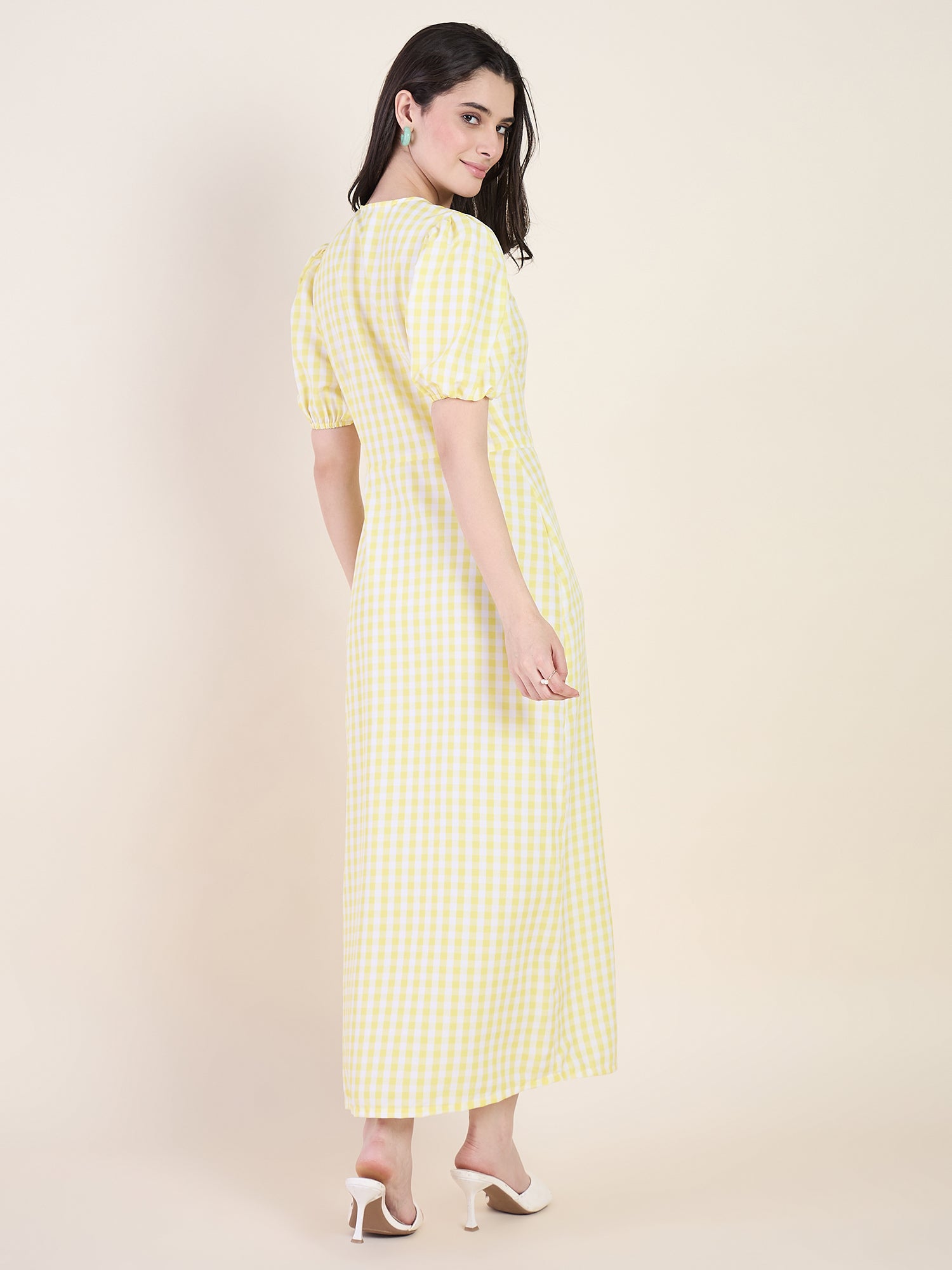 Woman wearing a yellow checkered dress on a beige background