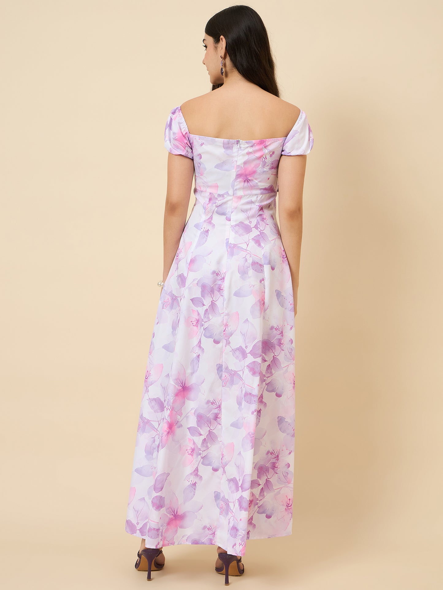 Woman wearing a floral off-shoulder dress on a beige background