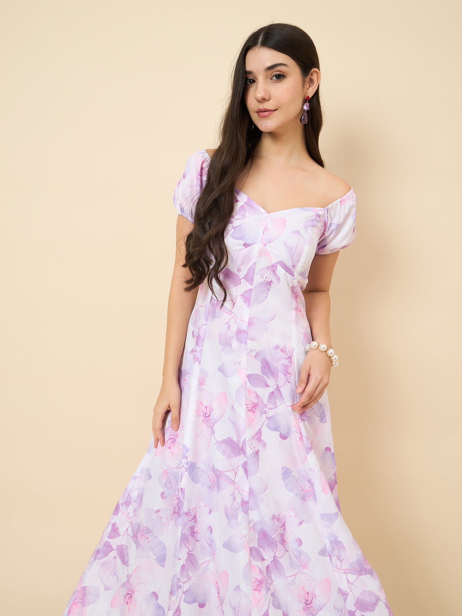 Woman wearing a floral off-shoulder dress on a beige background