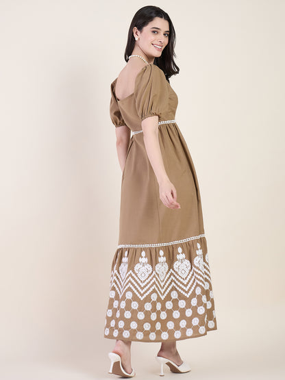 Woman wearing a brown dress with white patterns on a beige background