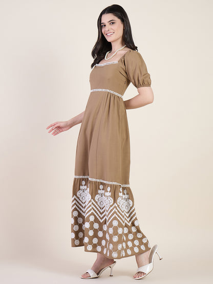 Woman wearing a brown dress with white embroidery on a beige background