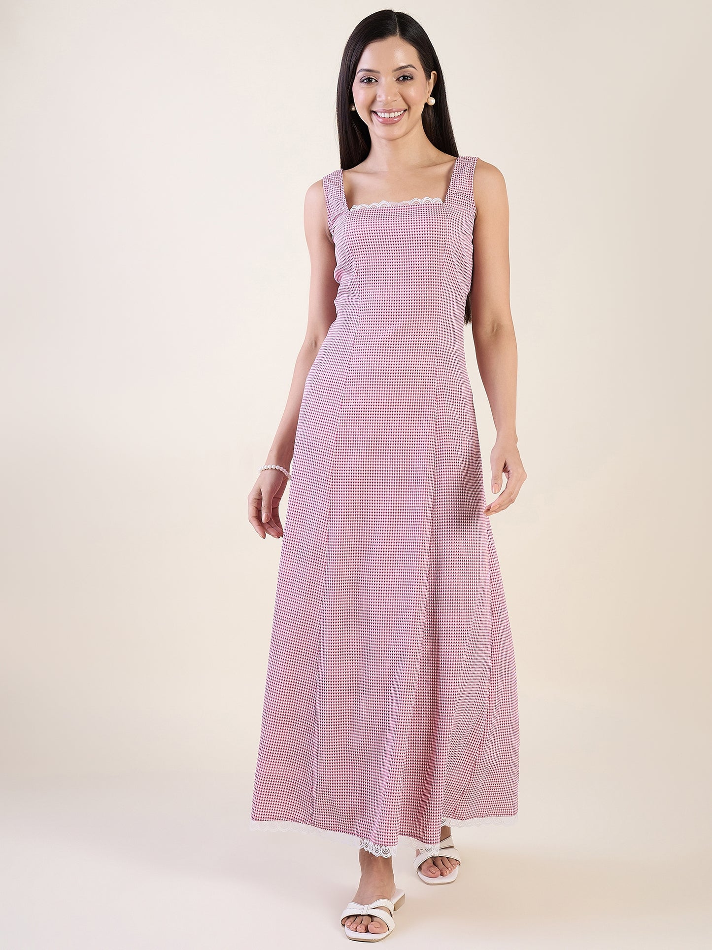 Woman wearing a pink and white striped dress on a plain background