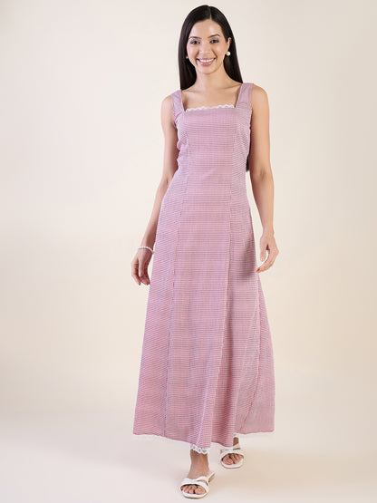 Woman wearing a pink and white striped dress on a plain background