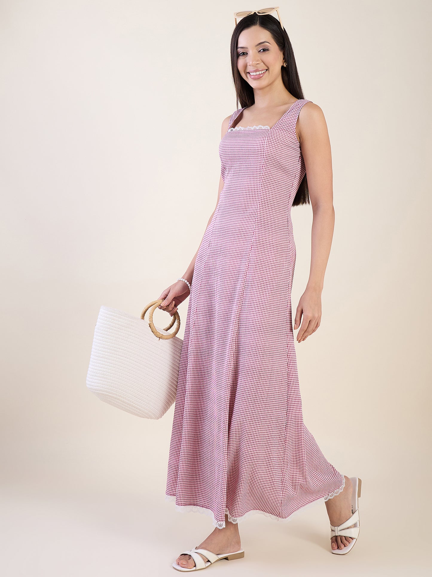 Woman wearing a pink dress holding a white bag against a beige background