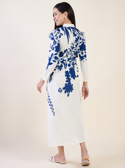 Woman wearing a white dress with blue floral pattern on a plain background