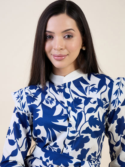 Woman wearing a blue and white floral blouse against a beige background