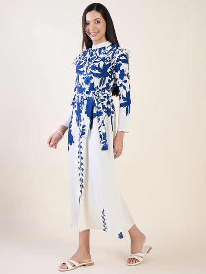 Woman wearing a white dress with blue floral patterns on a plain background