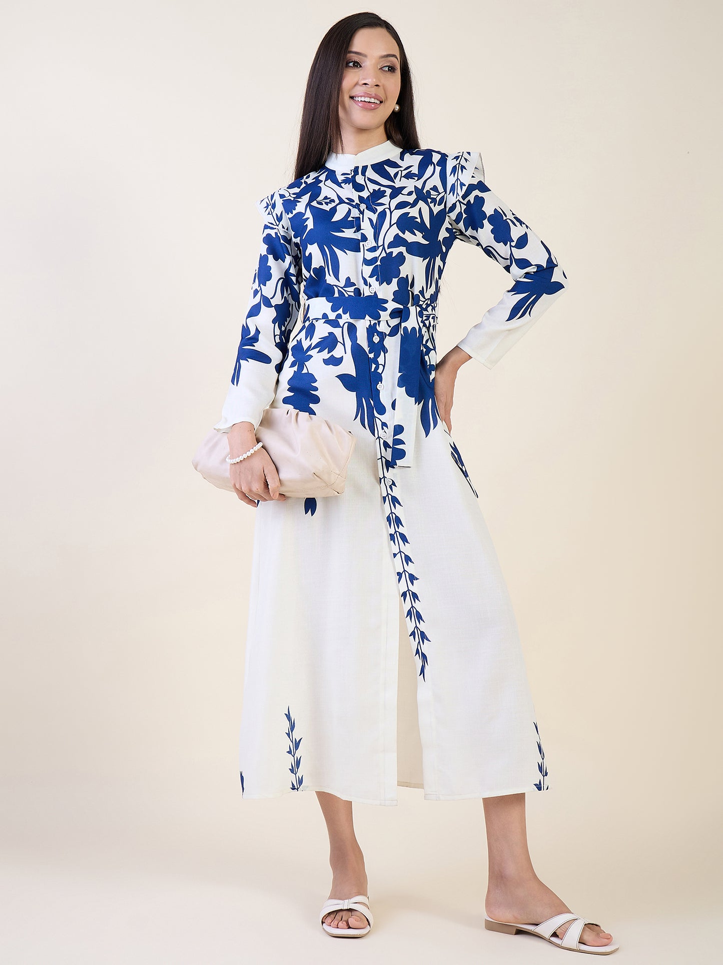 Woman wearing a blue and white floral dress on a plain background