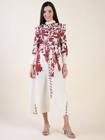 Woman wearing a white dress with red floral patterns on a plain background