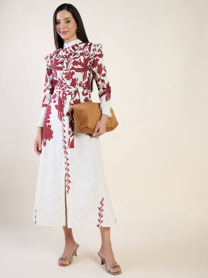 Woman wearing a white dress with red floral patterns, holding a brown clutch against a white background