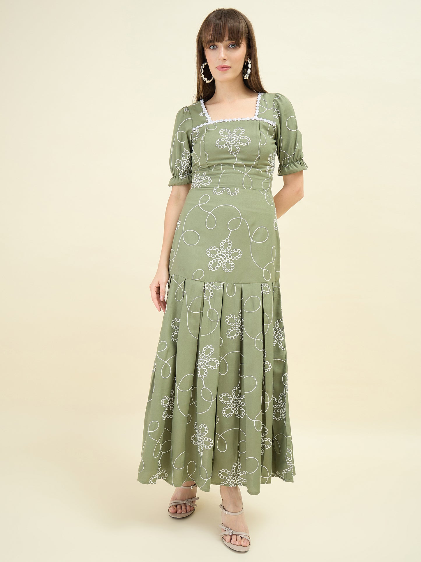 Woman wearing a green floral dress on a beige background