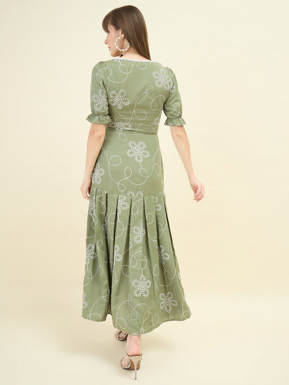 Woman wearing a green dress with floral patterns on a beige background