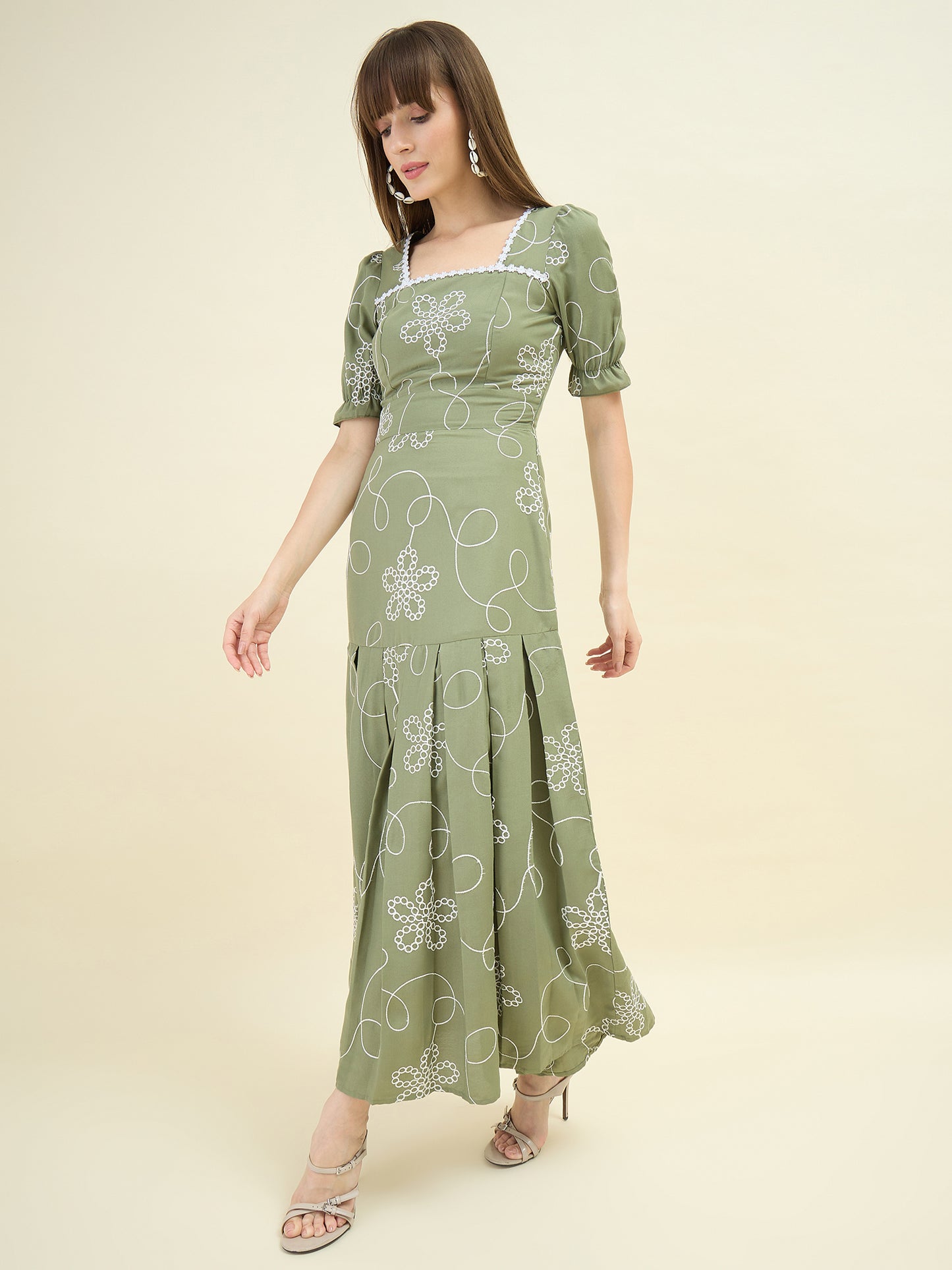 Woman wearing a green floral dress on a beige background