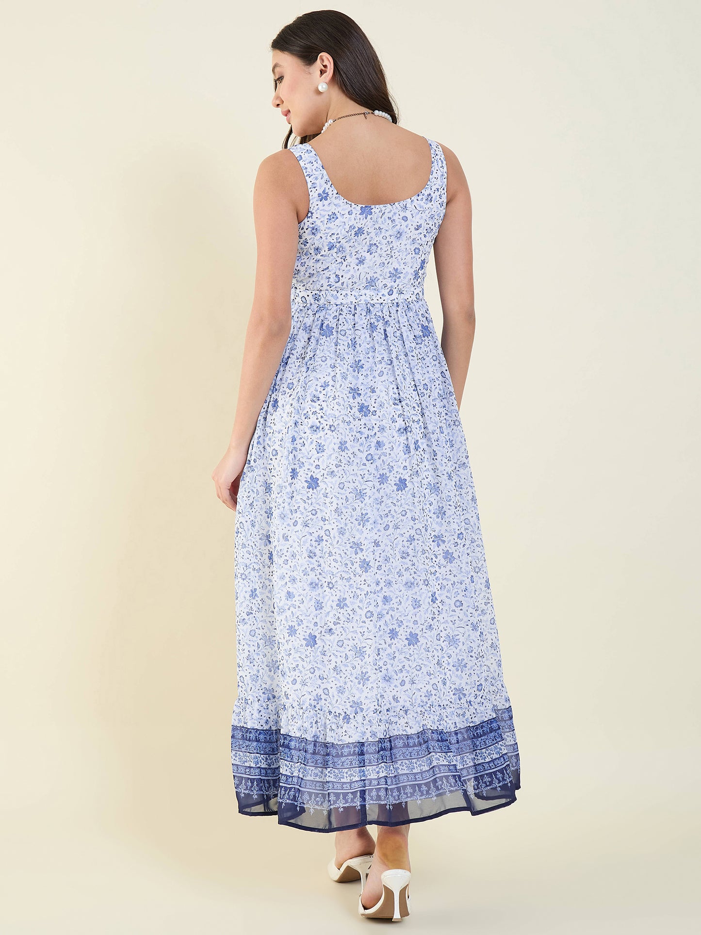 Woman wearing a blue floral dress on a beige background