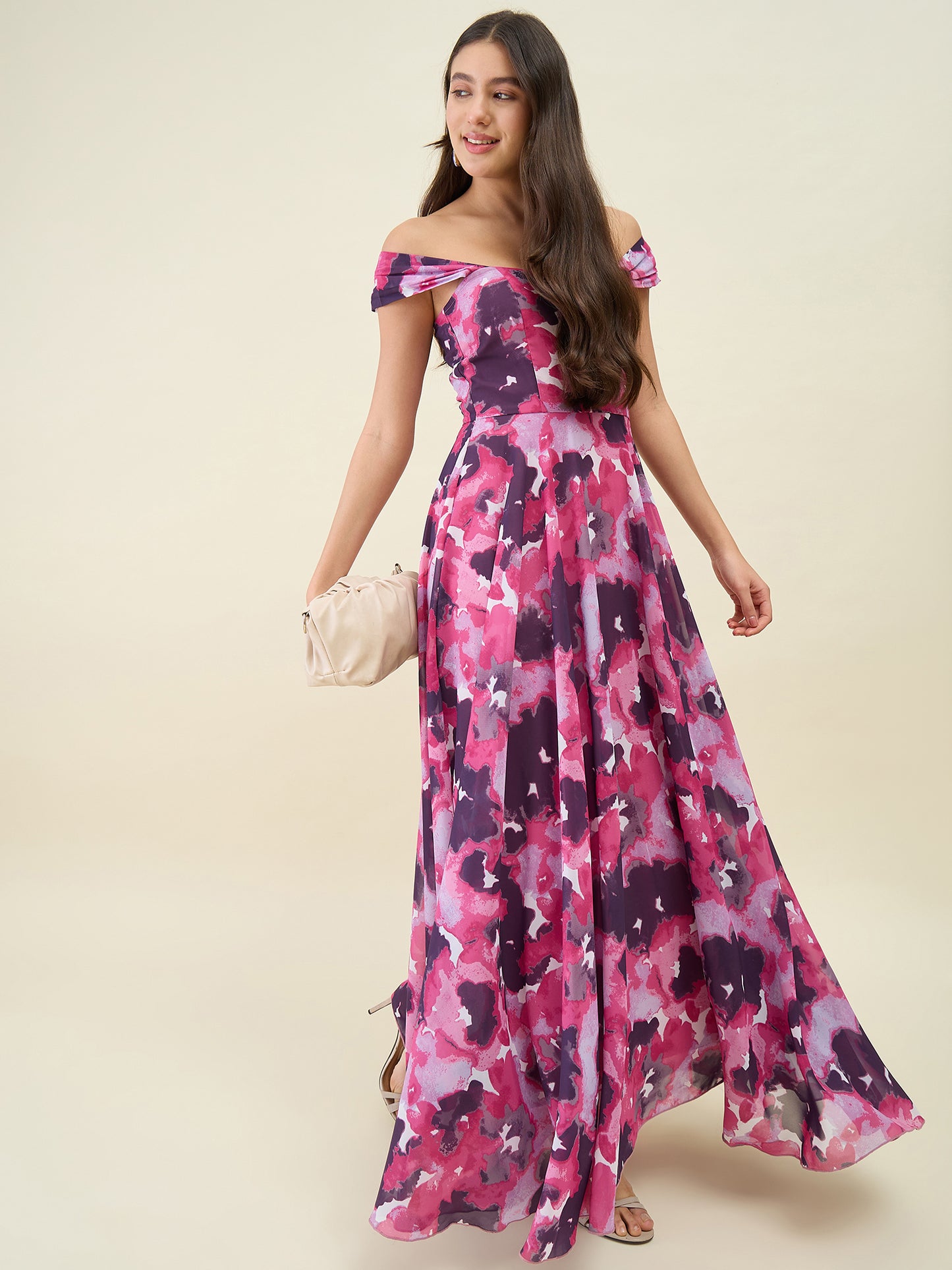 Woman wearing a pink and purple floral off-shoulder dress on a beige background