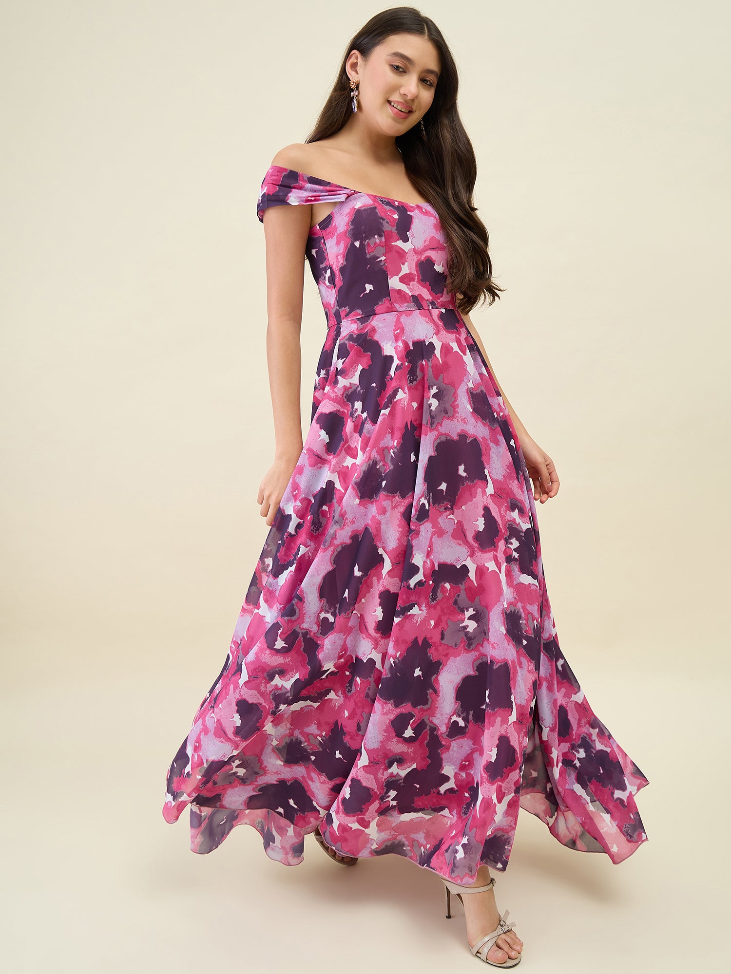 Woman wearing a pink and purple floral off-shoulder dress on a beige background