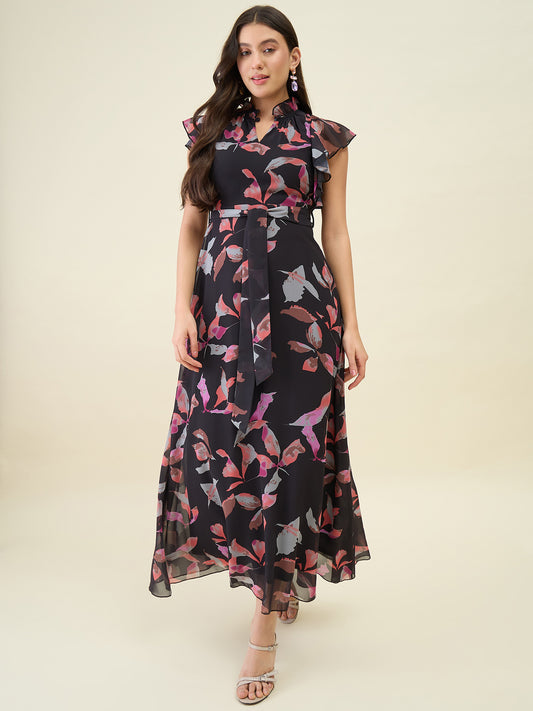 Woman wearing a black dress with pink floral pattern on a beige background