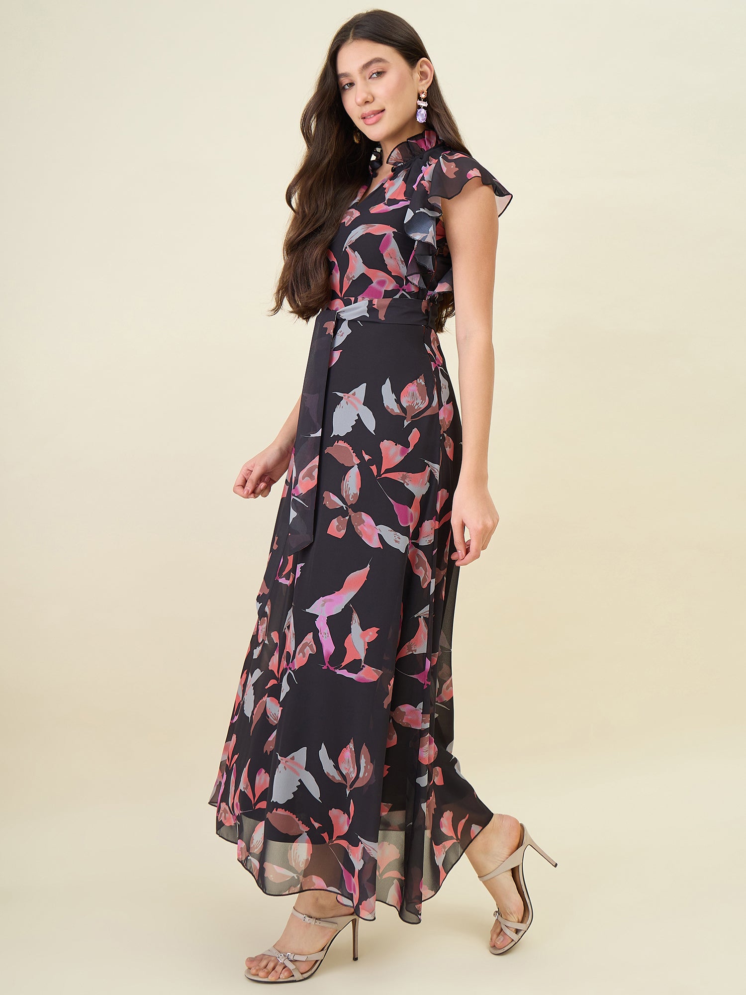 Woman wearing a black floral dress on a beige background