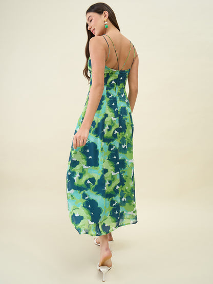 Woman wearing a green and blue patterned dress on a beige background