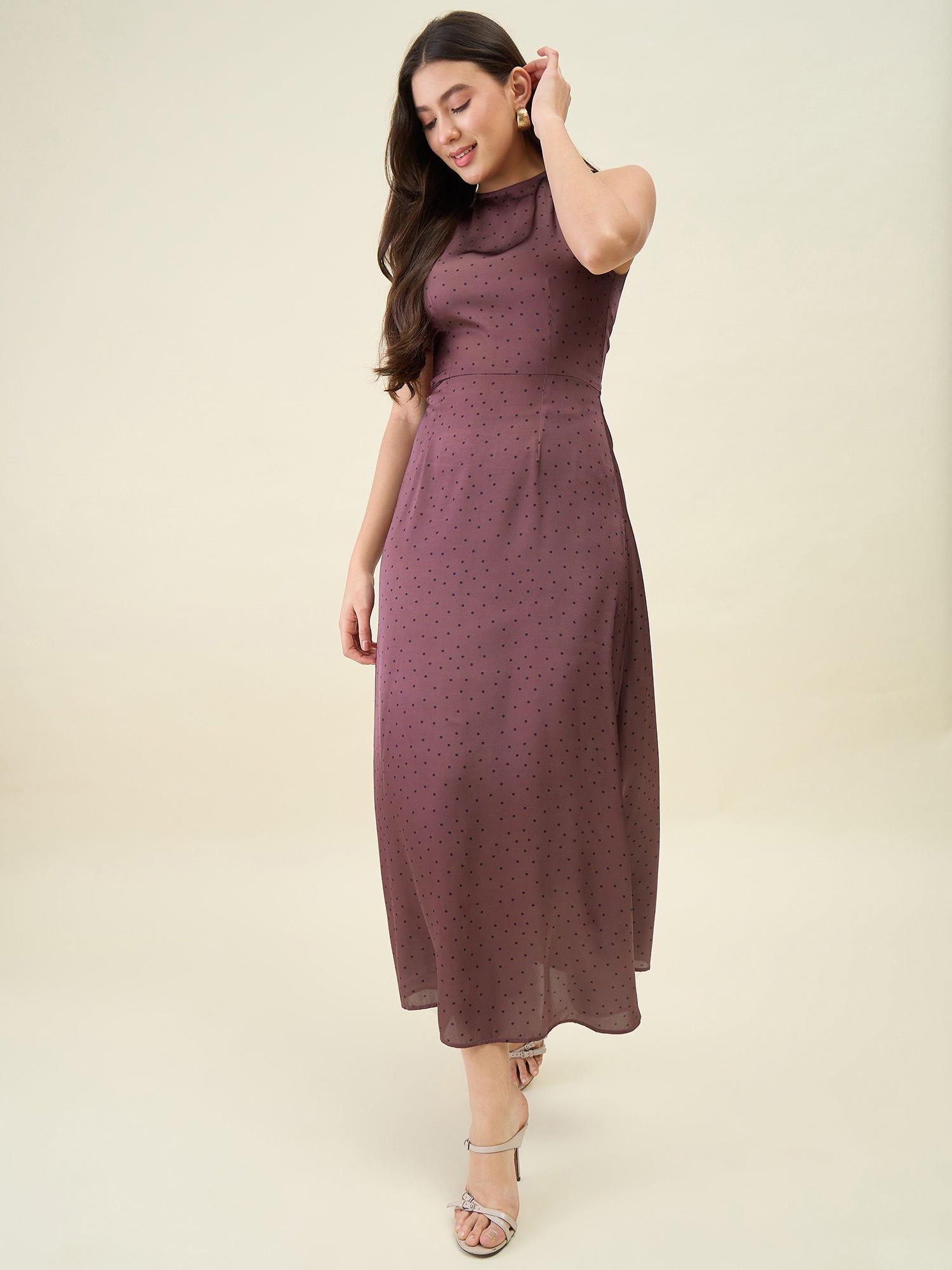 Woman wearing a brown dress against a plain background