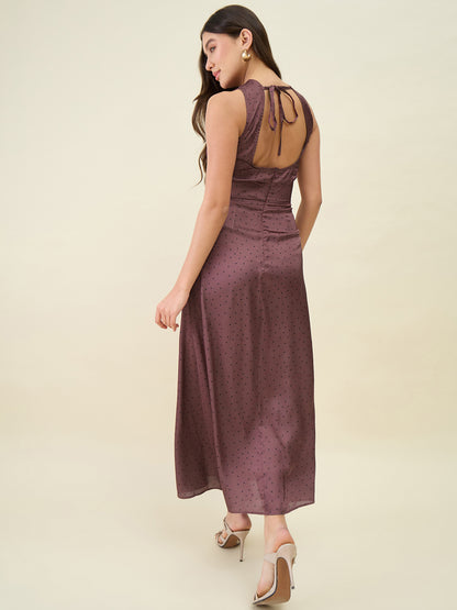 Woman wearing a brown dress with cut-out back on a beige background