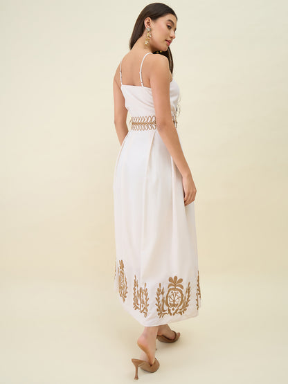 Woman wearing a white dress with gold embroidery on a beige background