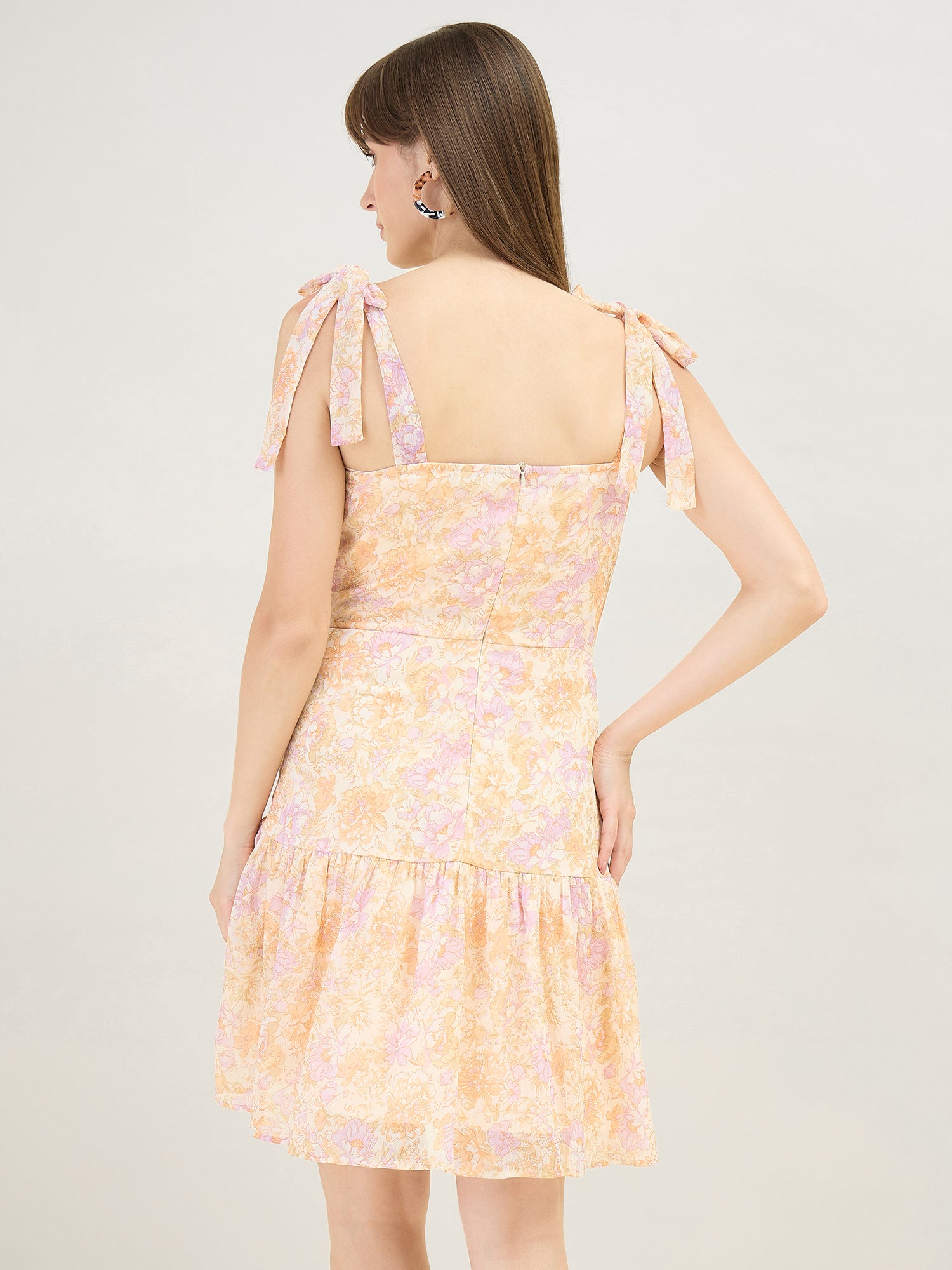 Woman wearing a floral dress with a plain background