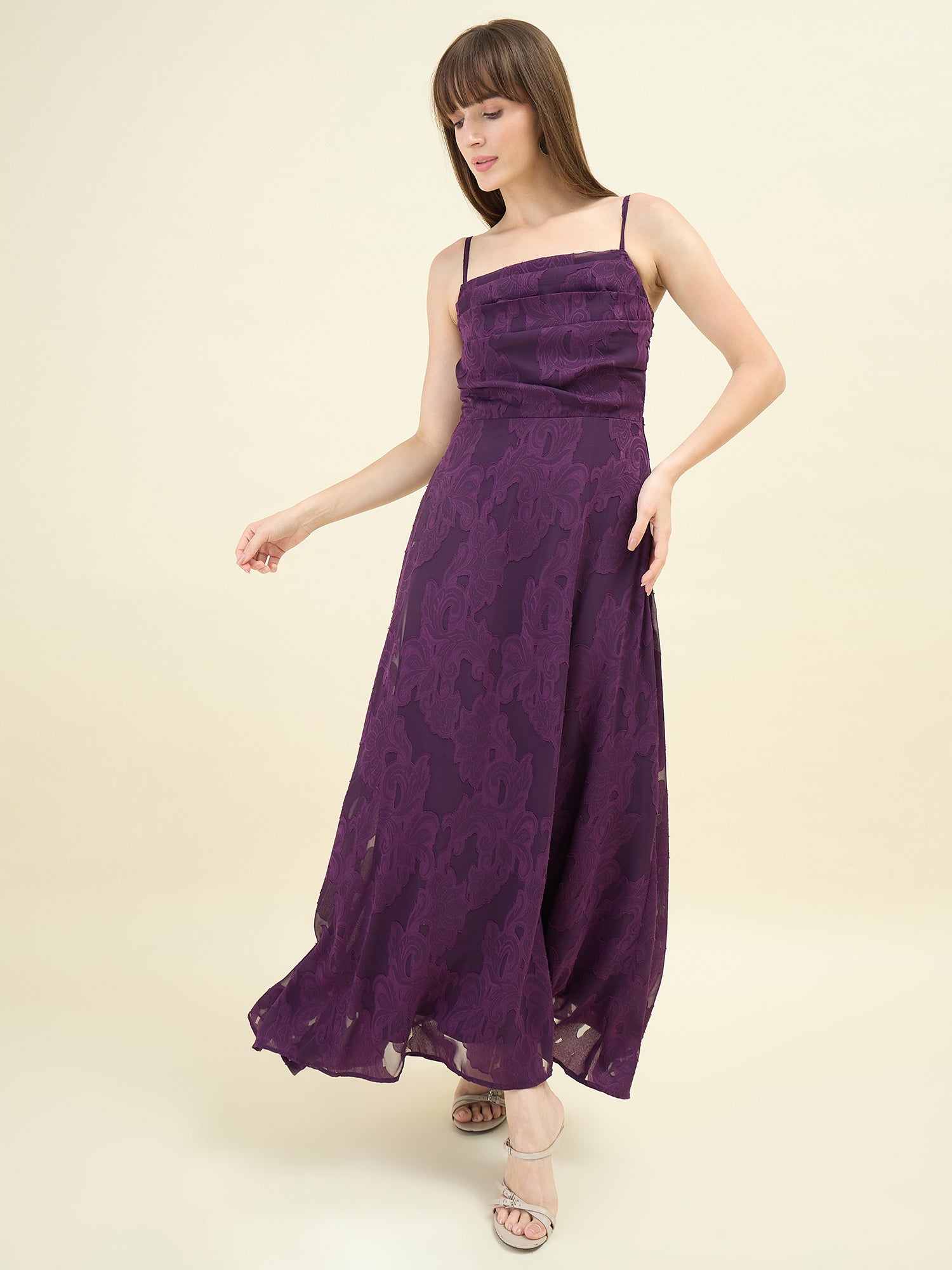 Woman wearing a purple dress against a beige background