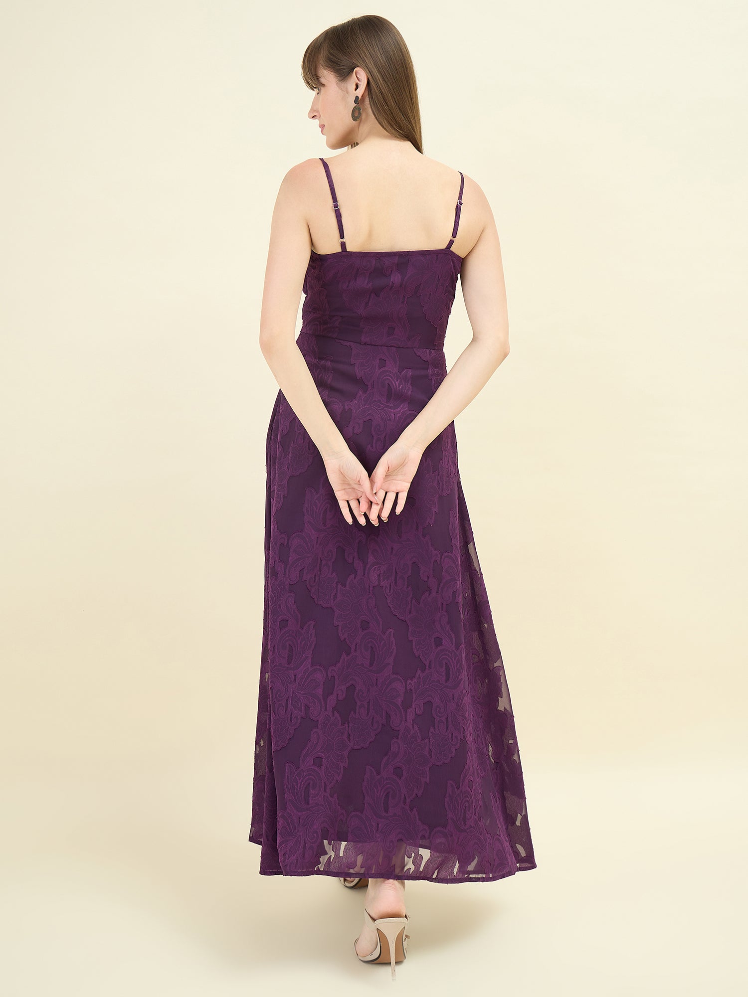 Woman wearing a purple lace dress on a beige background