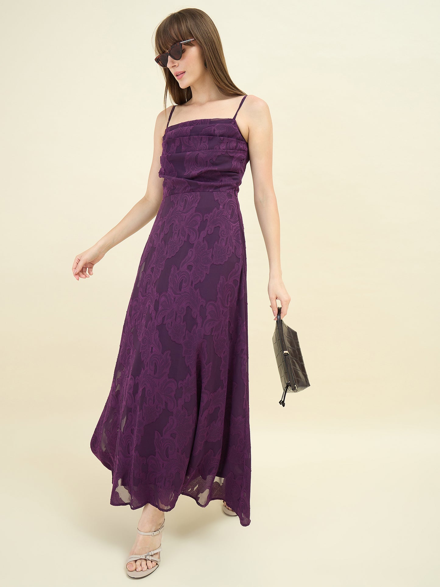 Woman wearing a purple floral dress against a beige background