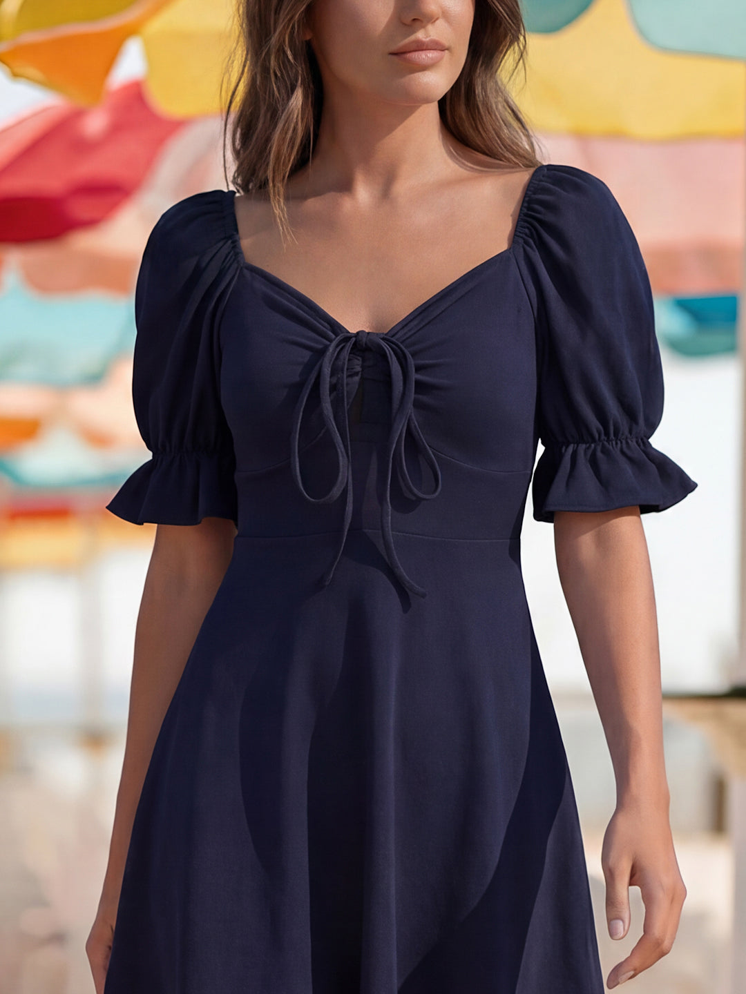 Navy blue dress with puff sleeves worn by a person, colorful blurred background