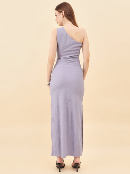 Woman wearing a one-shoulder purple dress against a beige background