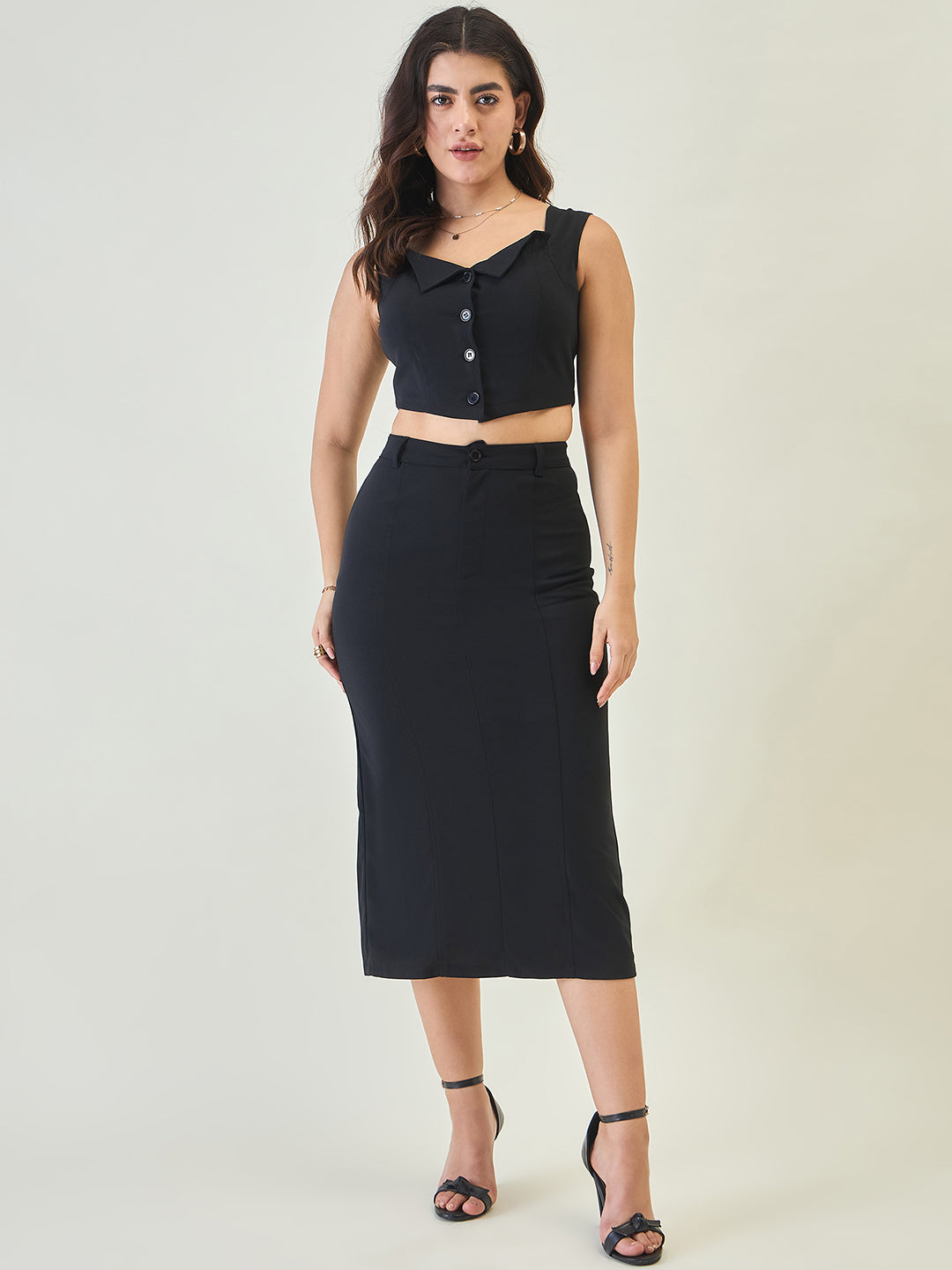 Woman wearing a black sleeveless top and skirt on a white background