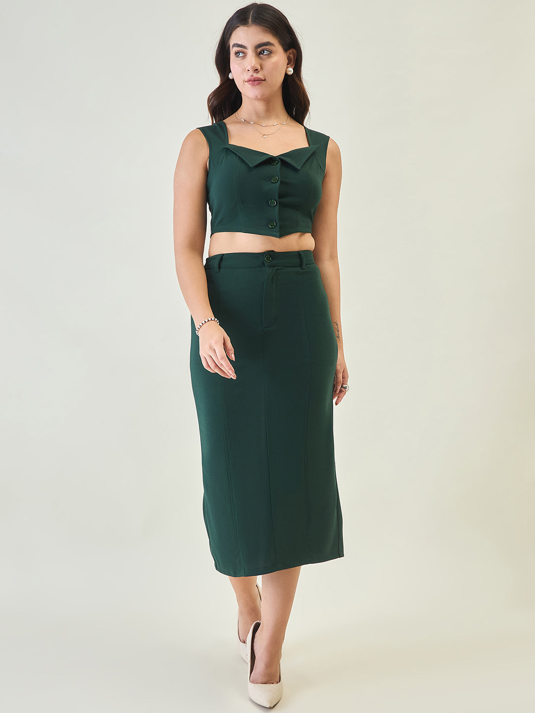 Woman wearing a green sleeveless top and skirt set on a white background