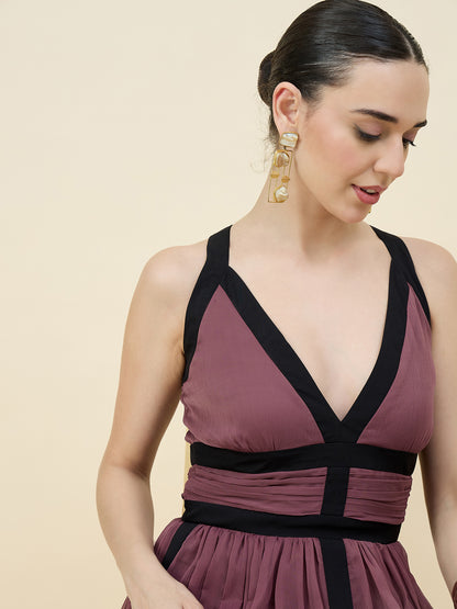 Woman wearing a mauve dress with black straps on a beige background