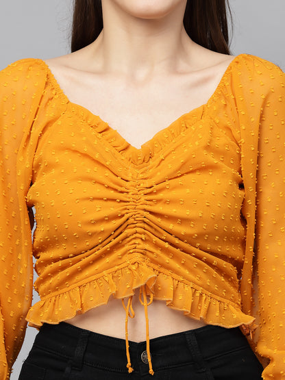 Yellow textured top worn by a person on a gray background