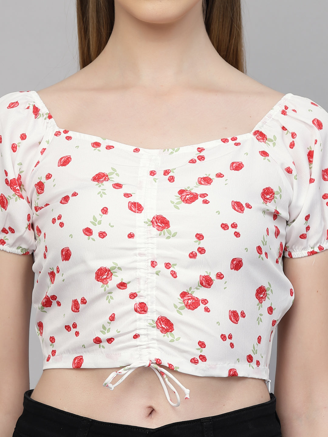 White crop top with red floral pattern worn by a model against a gray background