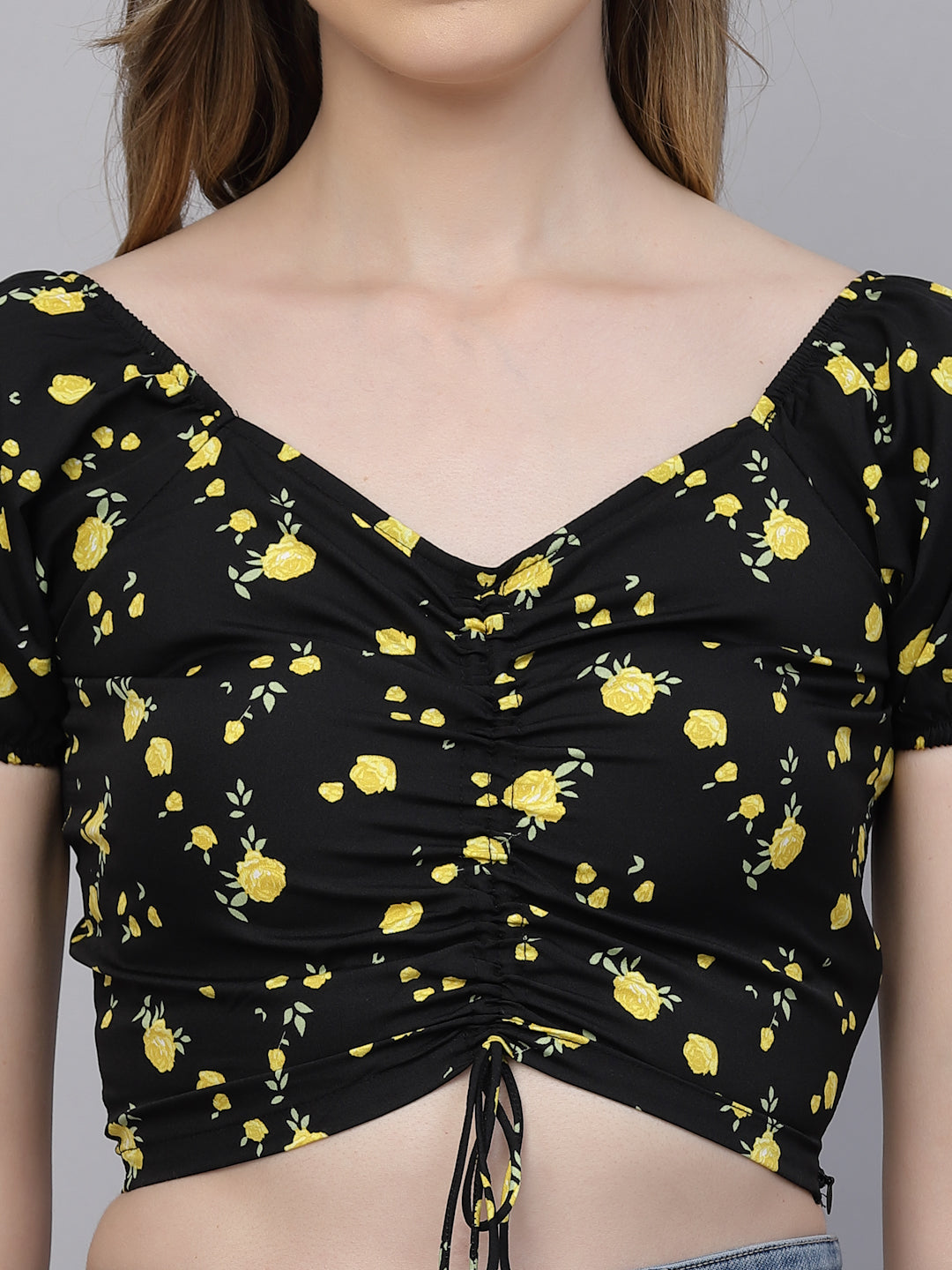 Black top with yellow floral pattern on a gray background
